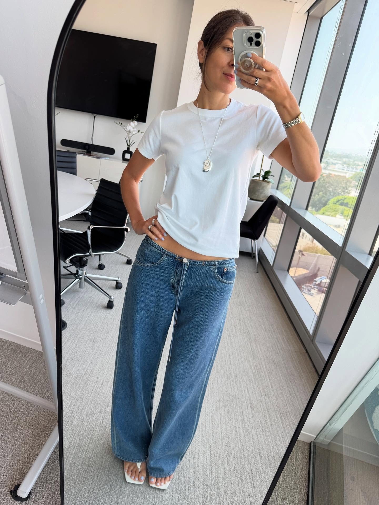 Woman in white t-shirt and low-rise jeans.
