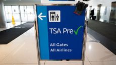 A sign in an airport indicating where TSA PreCheck members should go. 