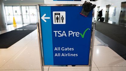 A sign in an airport indicating where TSA PreCheck members should go. 