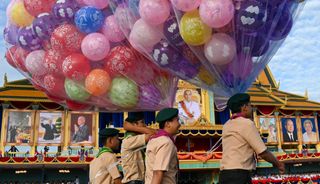 Scouts carry balloons during the 20th anniversary of Cambodian King Norodom Sihamoni's coronation