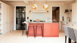 open plan kitchen with orange island unit and stools