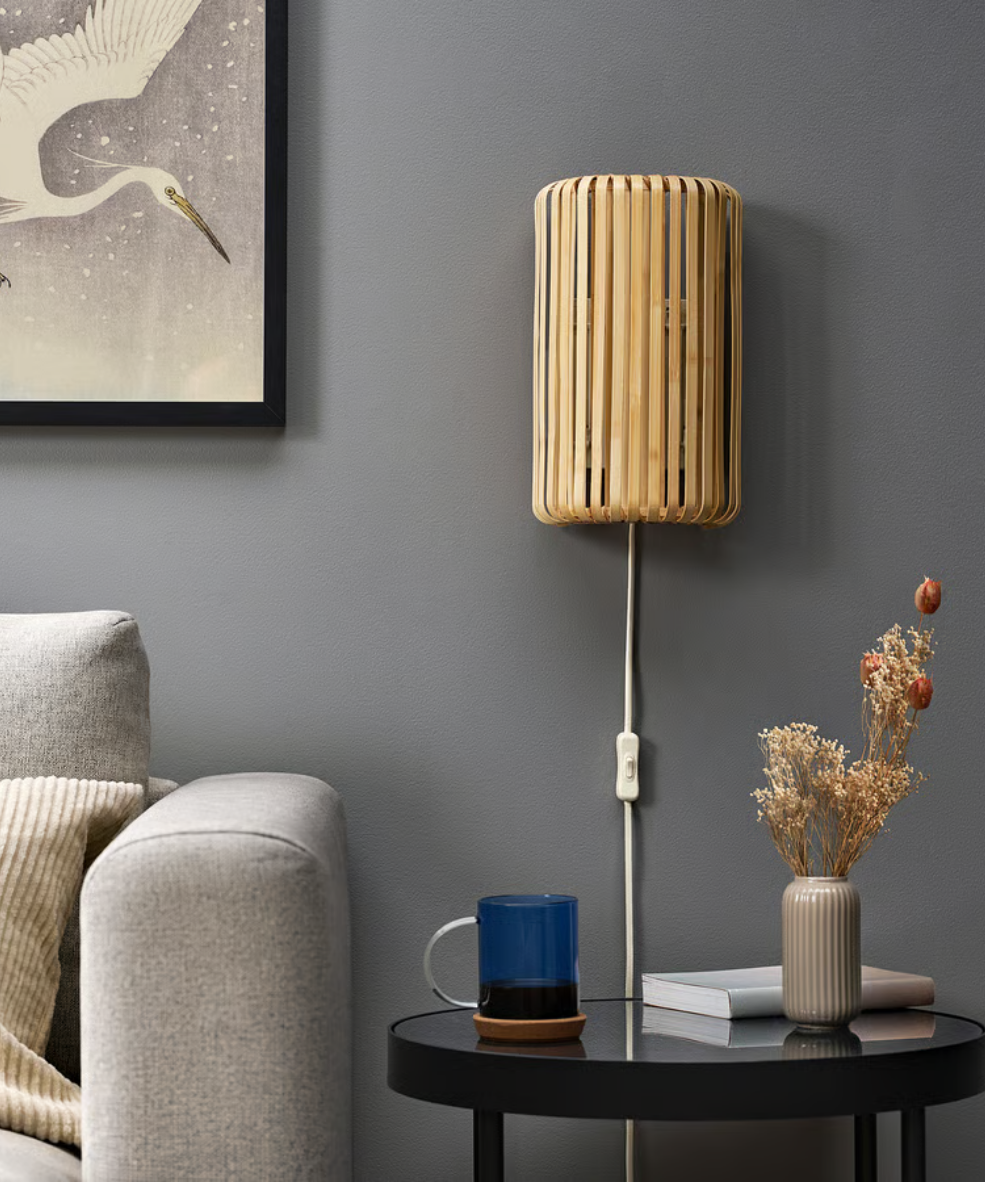 a plug in sconce mounted to a wall in a room with a couch and a small side table