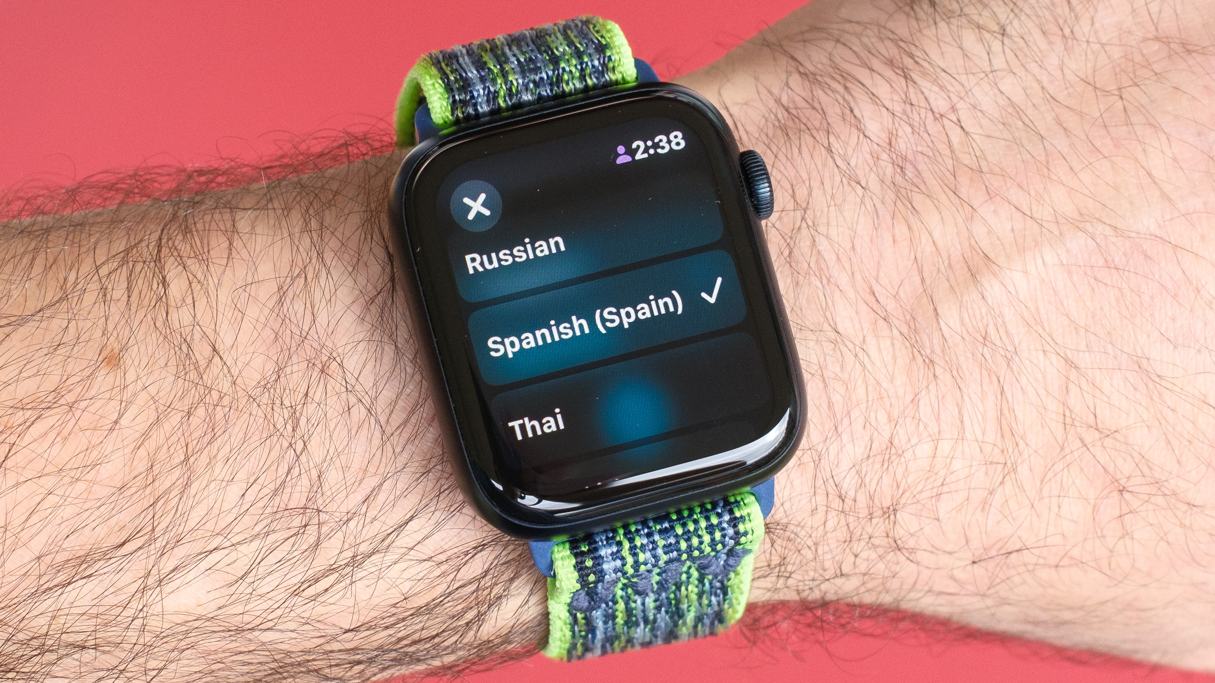 Close-up of an Apple Watch SE 2022 against a red background with the new Translate app on the screen