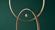 A wooden sphere in the center of intersecting rings against a green background.