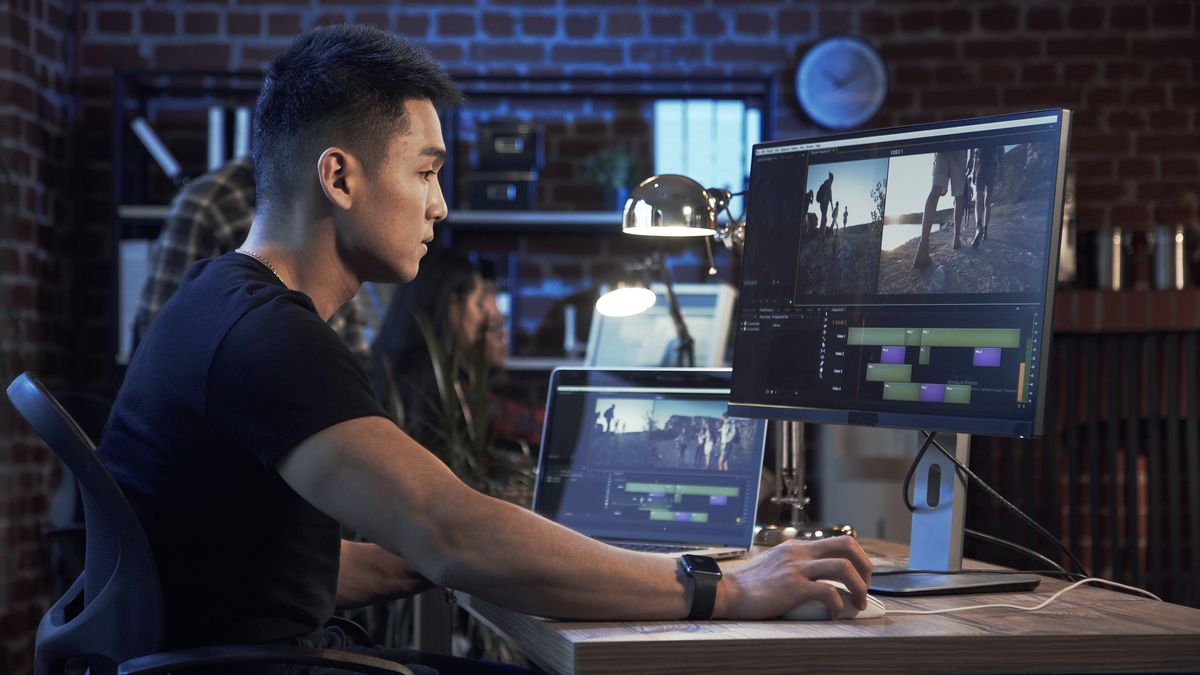 A man video editing on his computer in an office