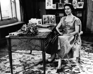 25th December 1957: Queen Elizabeth II smiling towards The Prince Philip, Duke of Edinburgh just before the end of her first Christmas Day television speech to her nation