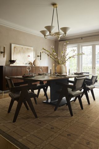 Goop x Ruggable in dining room with modern chandelier, black dining chairs and vase with flowers