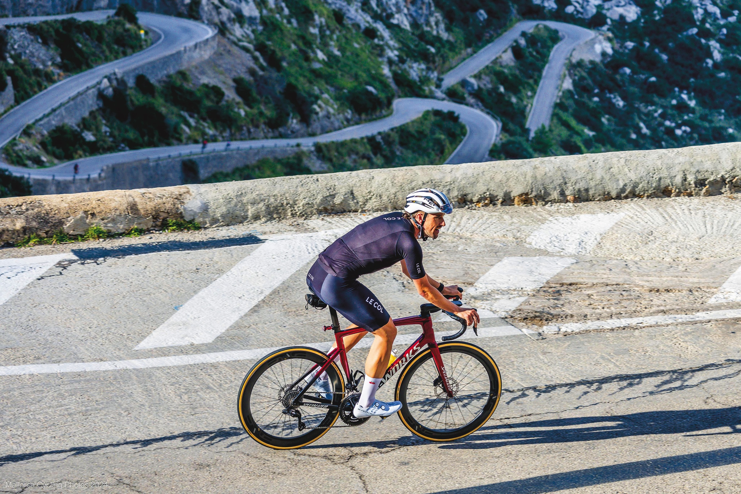 Michael Stanley in black kit and white helmet, competing in a road race