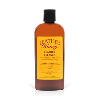 Leather Honey Leather Cleaner in orange glass bottle with black lid and yellow brand label