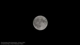 a fully illuminated moon against a black backdrop of sky.