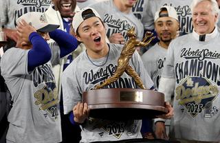 TORONTO, ONTARIO - NOVEMBER 02: Yoshinobu Yamamoto #18 of the Los Angeles Dodgers raises the Willie Mays World Series Most Valuable Player Award after defeating the Toronto Blue Jays 5-4 in game seven of the 2025 World Series at Rogers Center on November 02, 2025 in Toronto, Ontario. (Photo by Emilee Chinn/Getty Images)