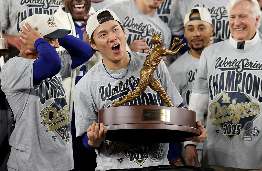 TORONTO, ONTARIO - NOVEMBER 02: Yoshinobu Yamamoto #18 of the Los Angeles Dodgers raises the Willie Mays World Series Most Valuable Player Award after defeating the Toronto Blue Jays 5-4 in game seven of the 2025 World Series at Rogers Center on November 02, 2025 in Toronto, Ontario. (Photo by Emilee Chinn/Getty Images)