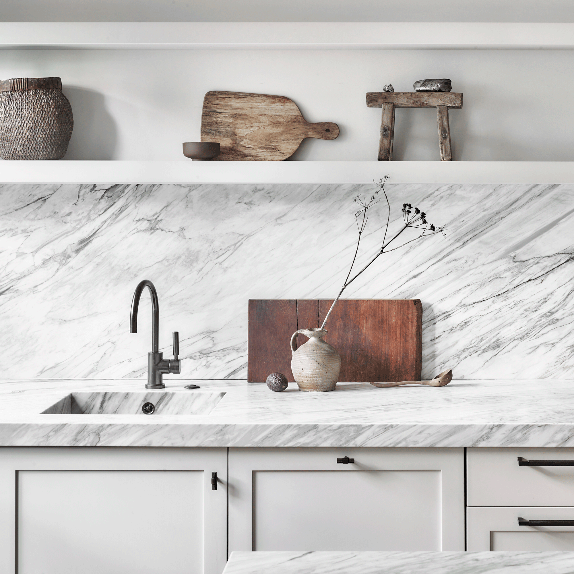 Close up of white marble veining kitchen splashback with shelf and wooden chopping boards