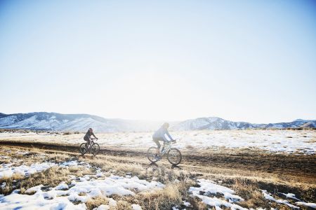 Two cyclists ride gravel in winter