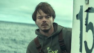 Wade Penney giving concerned look at something while standing on a boat in Netflix's Below