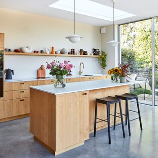 A contemporary, Scandi-style kitchen with pale wooden kitchen cabinets and kitchen island