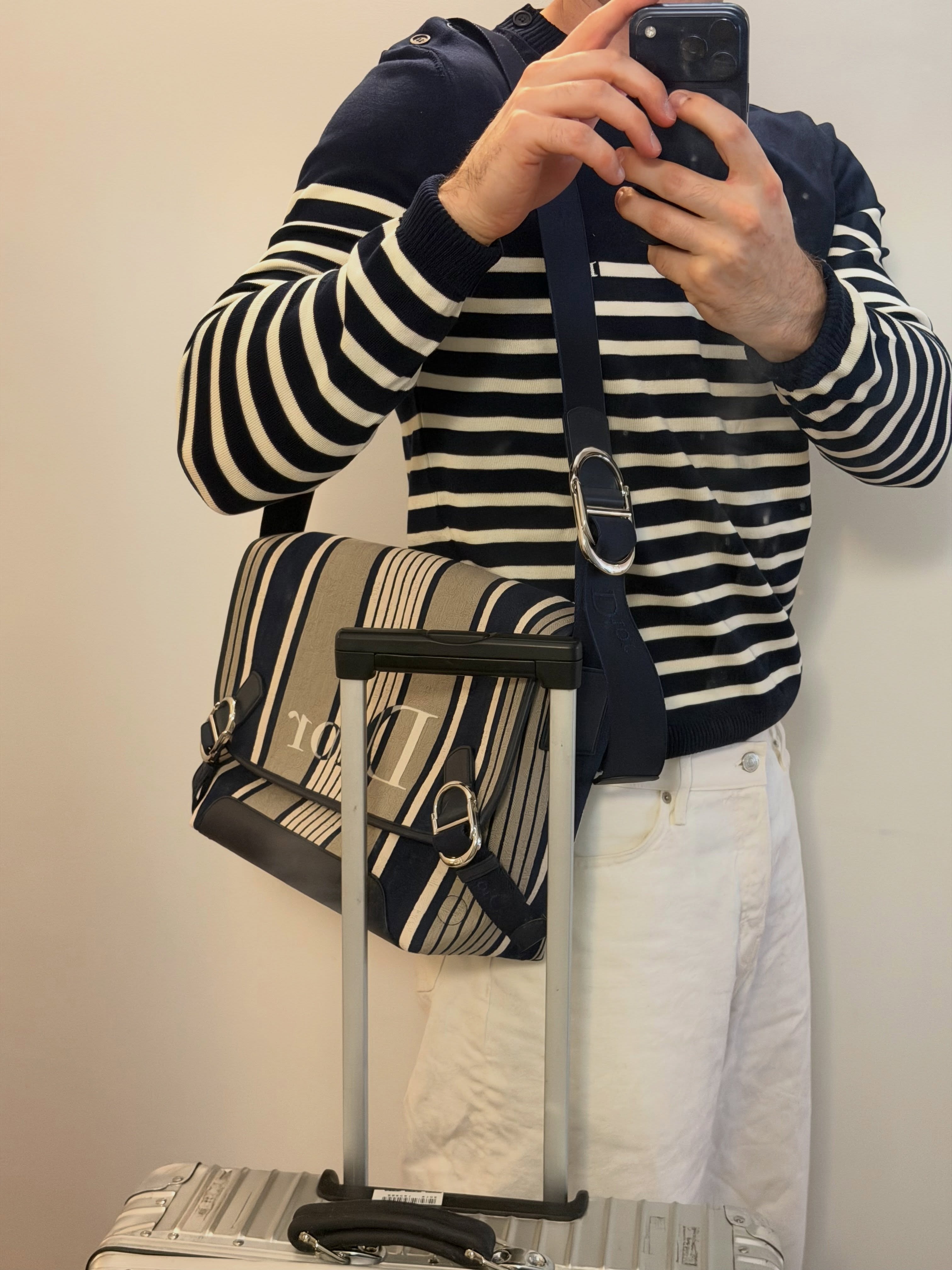 jack wears a stripe shirt, dior crossbody bag, white jeans.