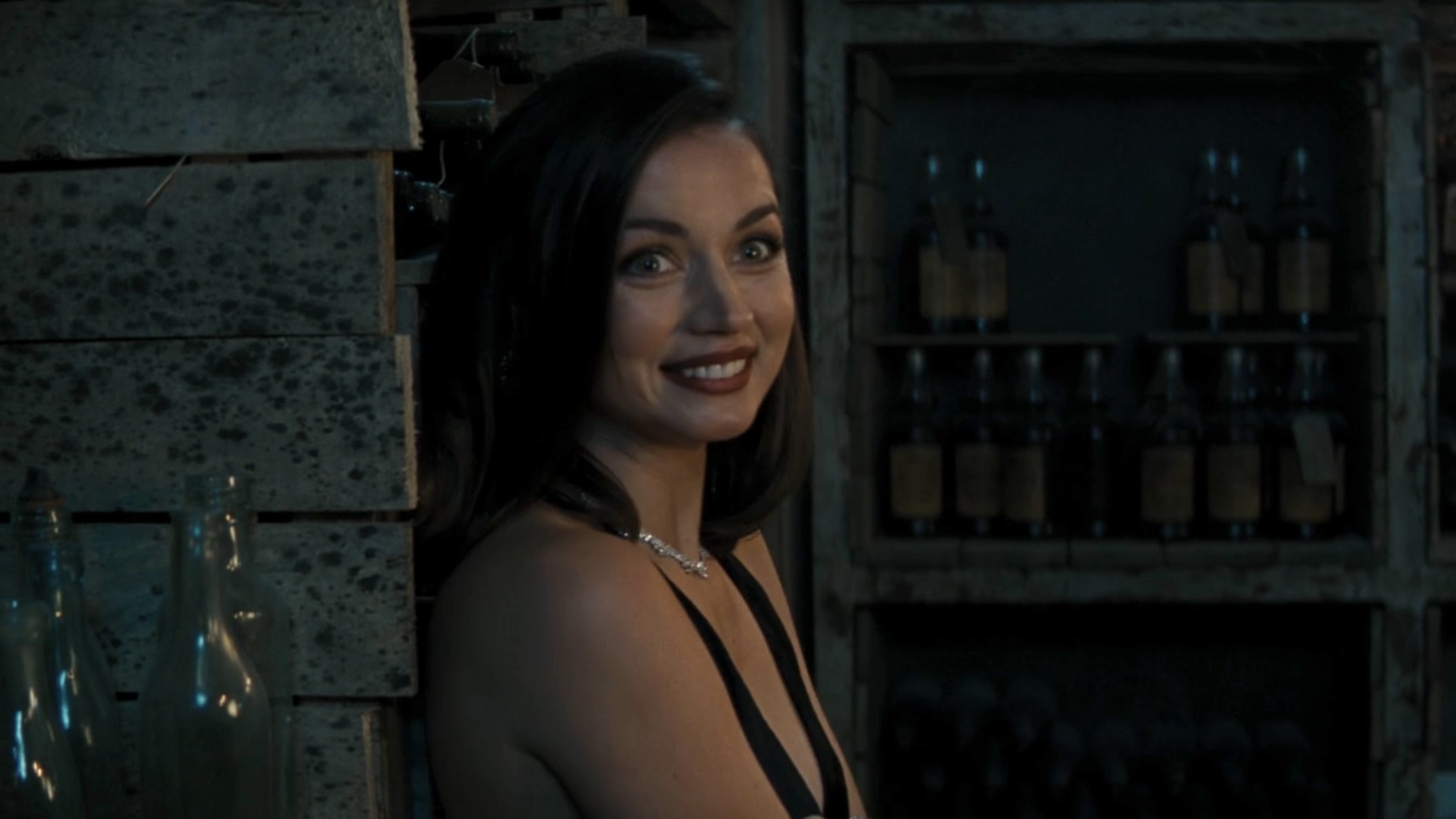 Ana de Armas smiling in a black dress in No Time to Die