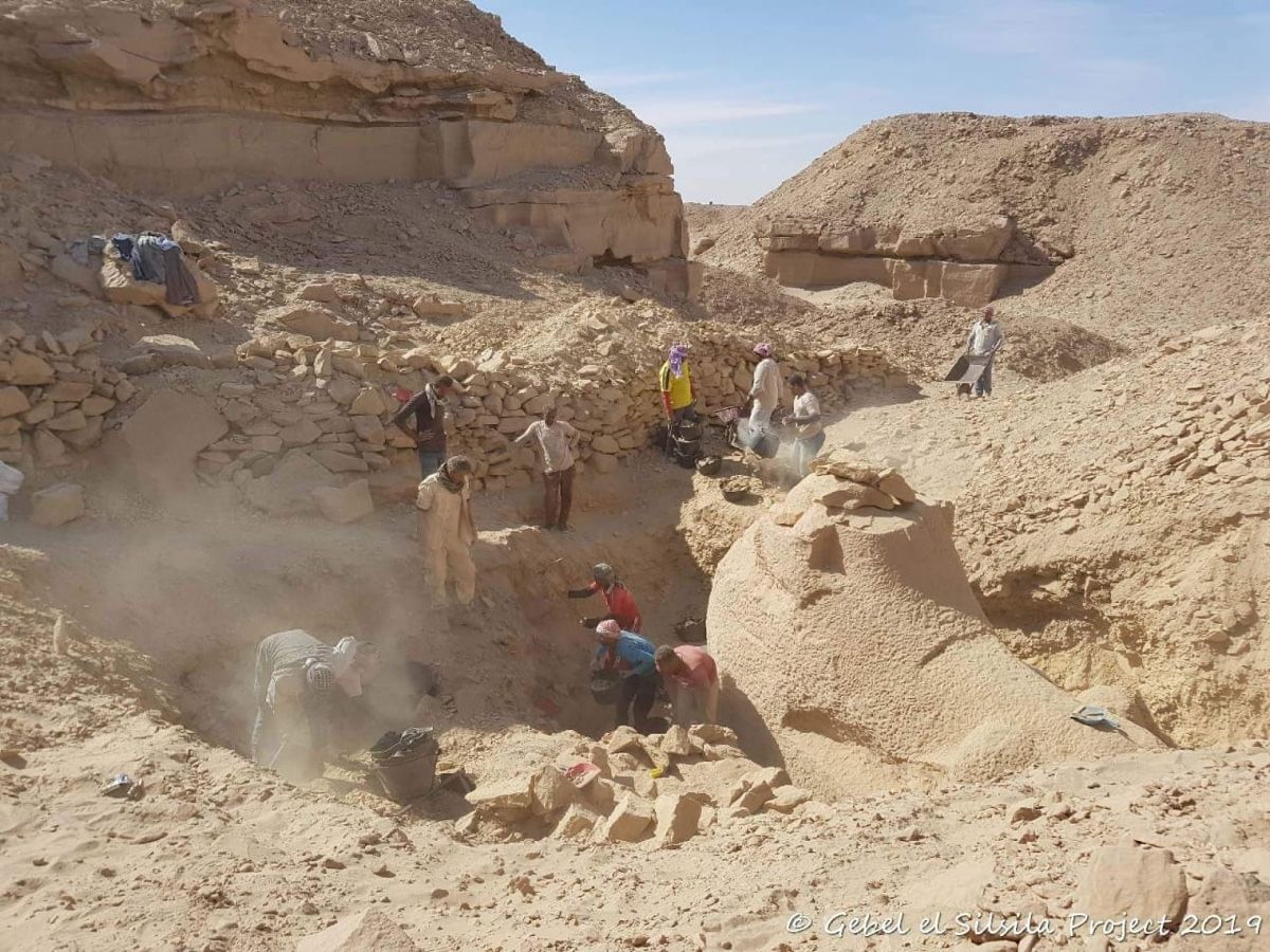 Workers dig a trench to excavate a large stone &quot;criosphinx&quot; (a sphinx with a ram&#039;s head) from quarry rubble at the Nile-side side of Gebel el-Silsila.