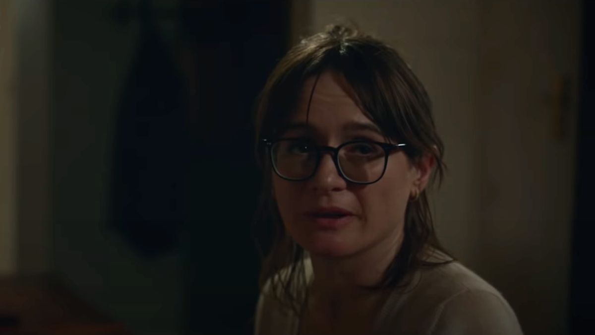 Emily Mortimer sitting at a piano, with glasses perched on her nose in Relic.