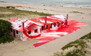 High view of red painted house looking out onto the beach