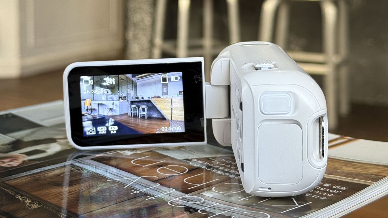 Yashica Journey 4K camcorder in white, rested on a surface with screen flipped out