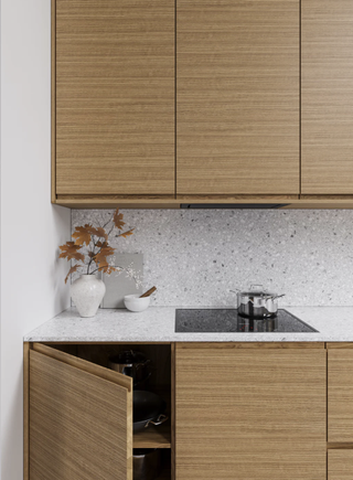 Contemporary kitchen cabinets in a white oak finish with a terrazza backsplash