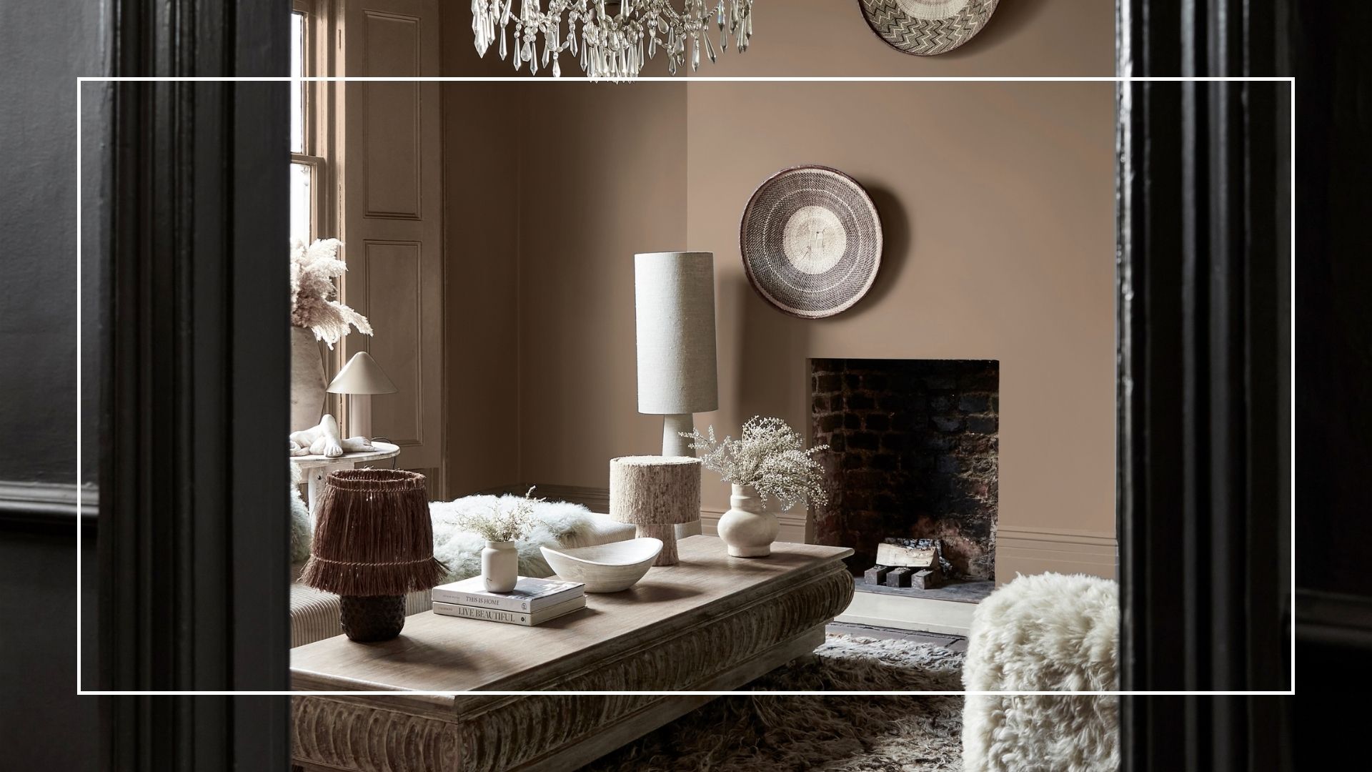 looking through the doorway of a brown living room with textured furniture and a stone coffee table