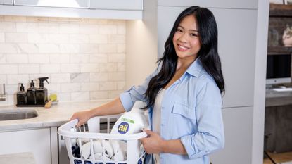 Suni Lee in her laundry room holding a laundry basket