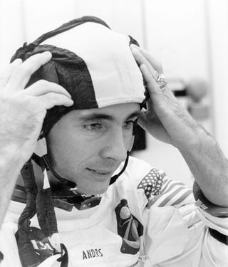 black and white photo of a man wearing a spacesuit, with his helmet off