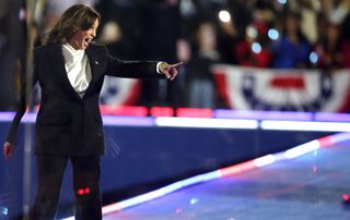 A photo of Kamala Harris wearing a white cowl-neck blouse with long sleeves