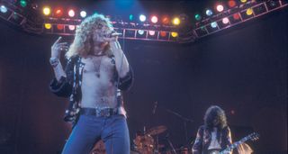 A bare-chested Robert Plant of Led Zeppelin performs at Earl's Court, London, in 1975. Guitarist Jimmy Page plays his Gibson Les Paul Standard in the background.
