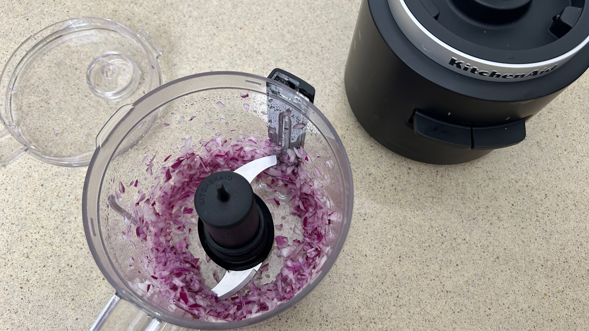 A small red onion chopped in the KitchenAid Go Cordless Food Chopper