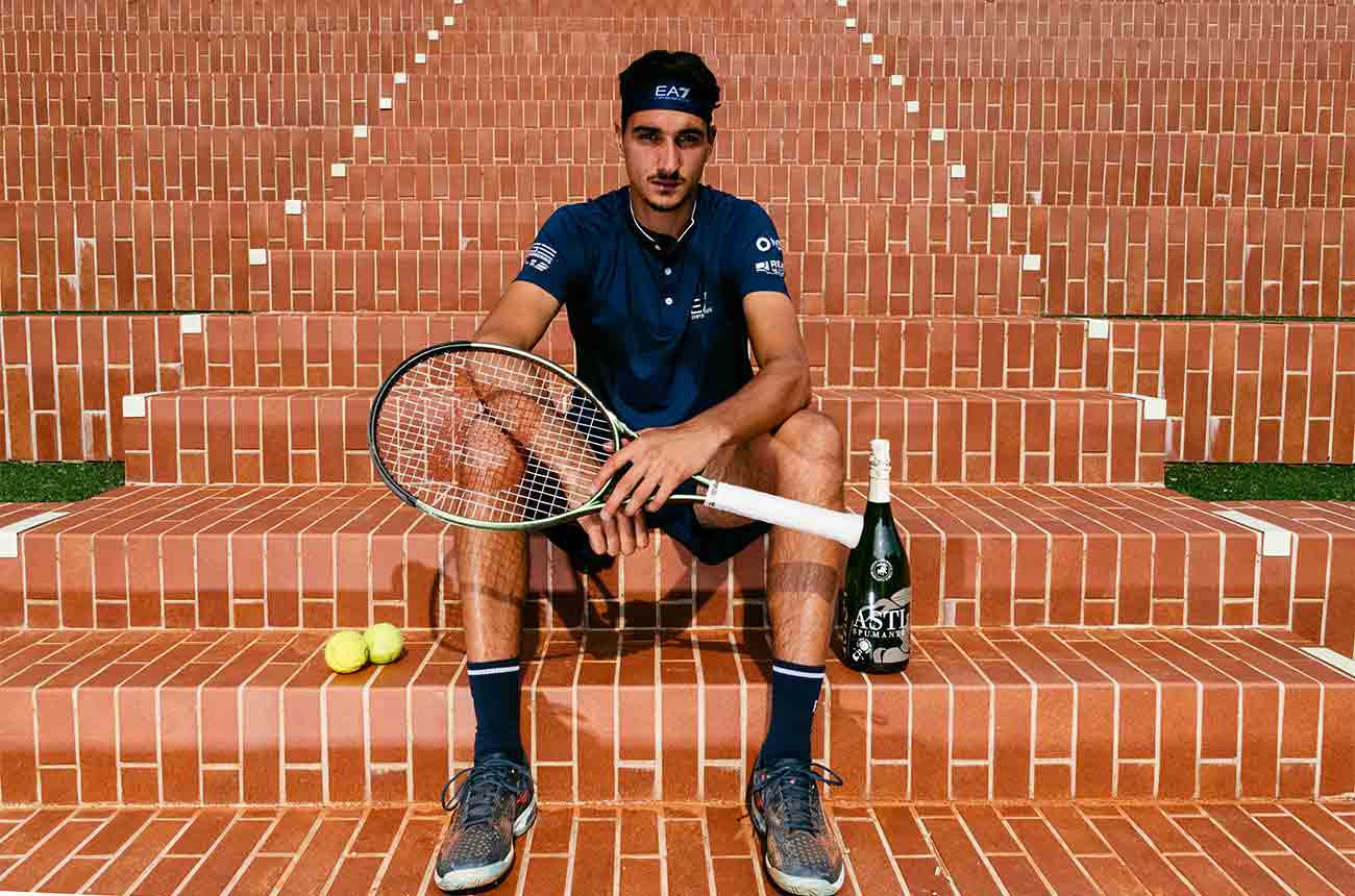 Italian professional tennis player, Lorenzo Sonego with bottle of Asti sparkling wine