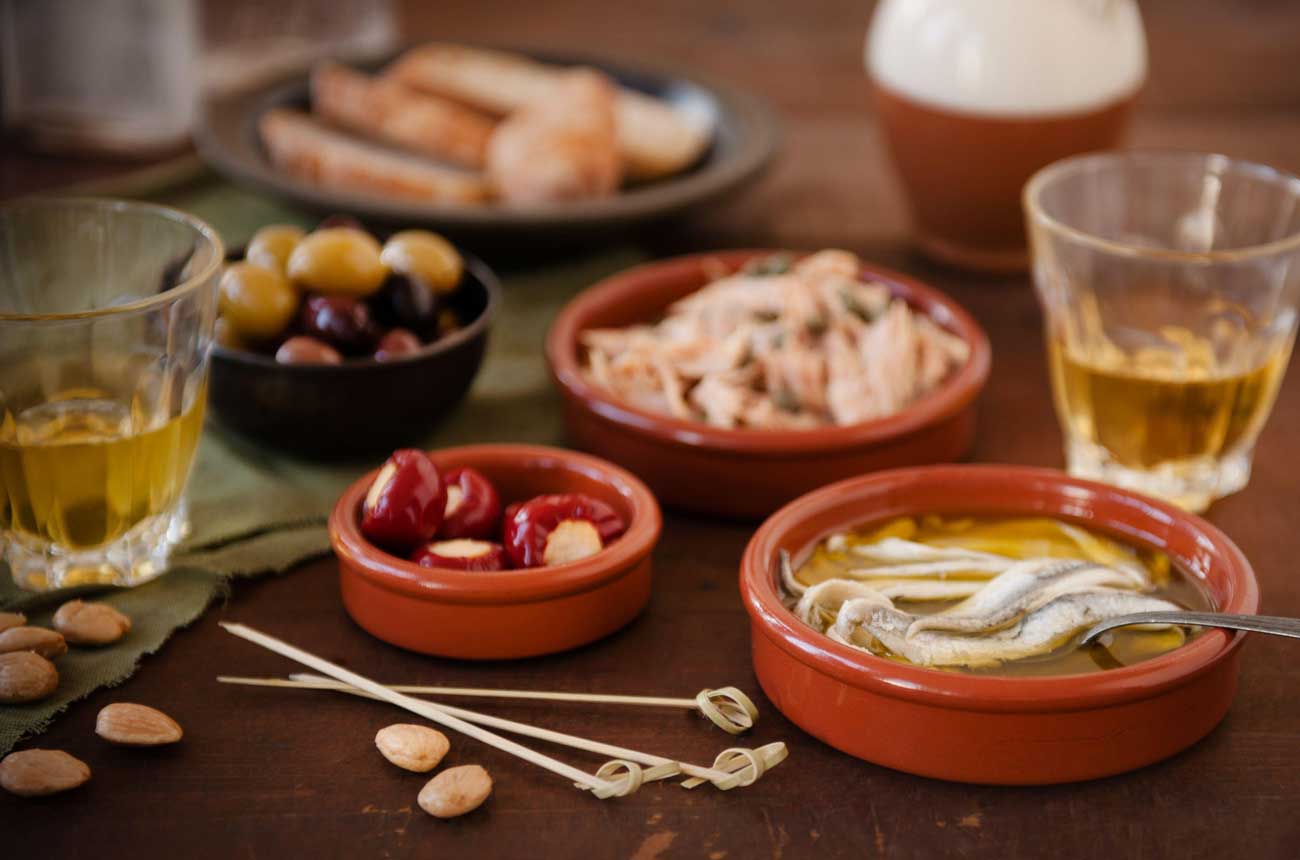 Spanish Tapas with Tuna and Capers, Olives, Anchovies, Cheese Stuffed Peppers, Almonds and White Wine