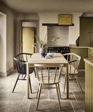 A rustic kitchen with extended dining table, loveseat bench