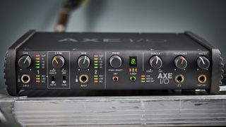 How to choose an audio interface: IK Multimedia Axe I/O with a guitar in the background