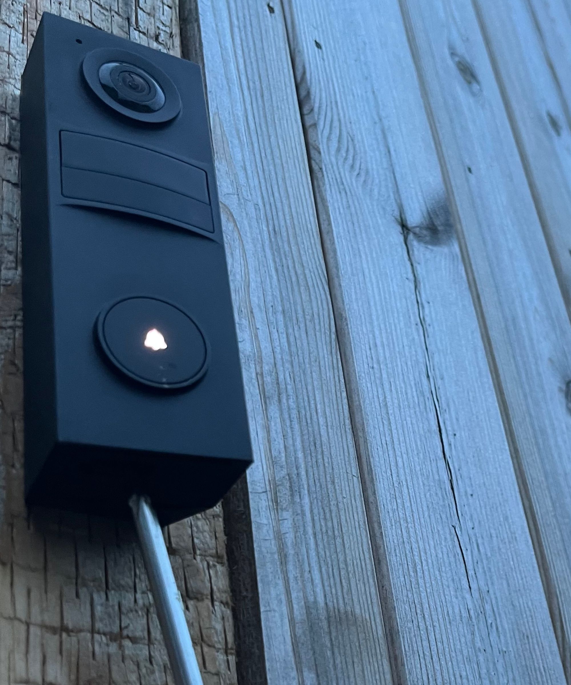 Tapo D205 Smart Video Doorbell being installed onto a wooden fence with screw driver