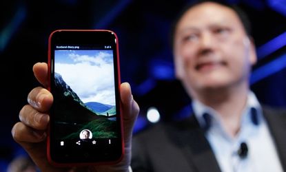 HTC CEO Peter Chou holds the new Android program Facebook Home, which, according to some, is "off to a rough start."