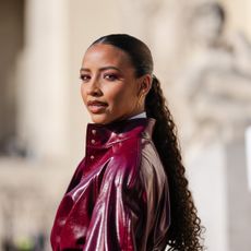 best conditioners - Flora Coquerel wears gold earrings, white buttoned up long sleeve shirt, burgundy bordeaux necktie, shiny burgundy bordeaux belted leather jacket - getty images 2204169564