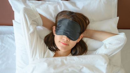 woman wearing eye mask in bed
