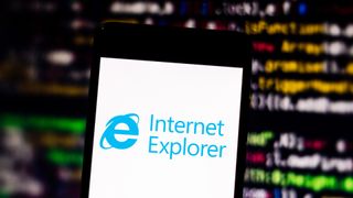 The Internet Explorer icon as seen on a smartphone in behind a screen with lines of code