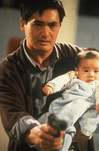 Tequila (Chow-Yun Fat) fights off the Triad gangsters while holding an infant (notice the cotton in his ears) during the eye-popping hospital shootout in John Woo's masterpiece