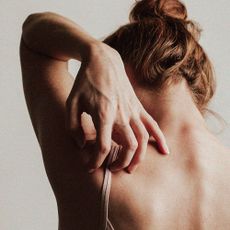 Woman scratching her back - types of eczema
