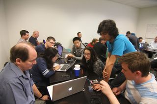 Manu Sharma (right, standing) assists Eric Dahlstrom (left) and Ryan Gillespie (right) in a hands-on exercise during the Space Hacker Workshop in Mountain View, Calif. in May 2013.