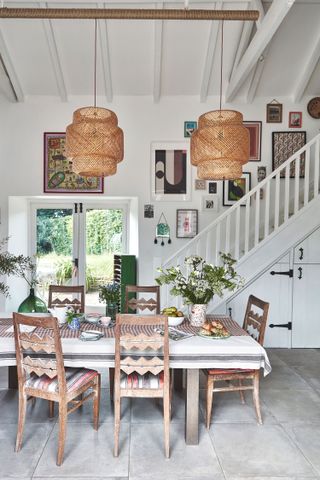 gallery wall above staircase in kitchen with wooden table