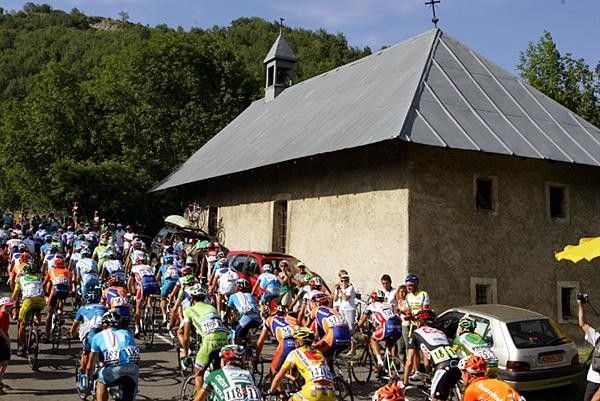 Riders pass an older house along the climb.