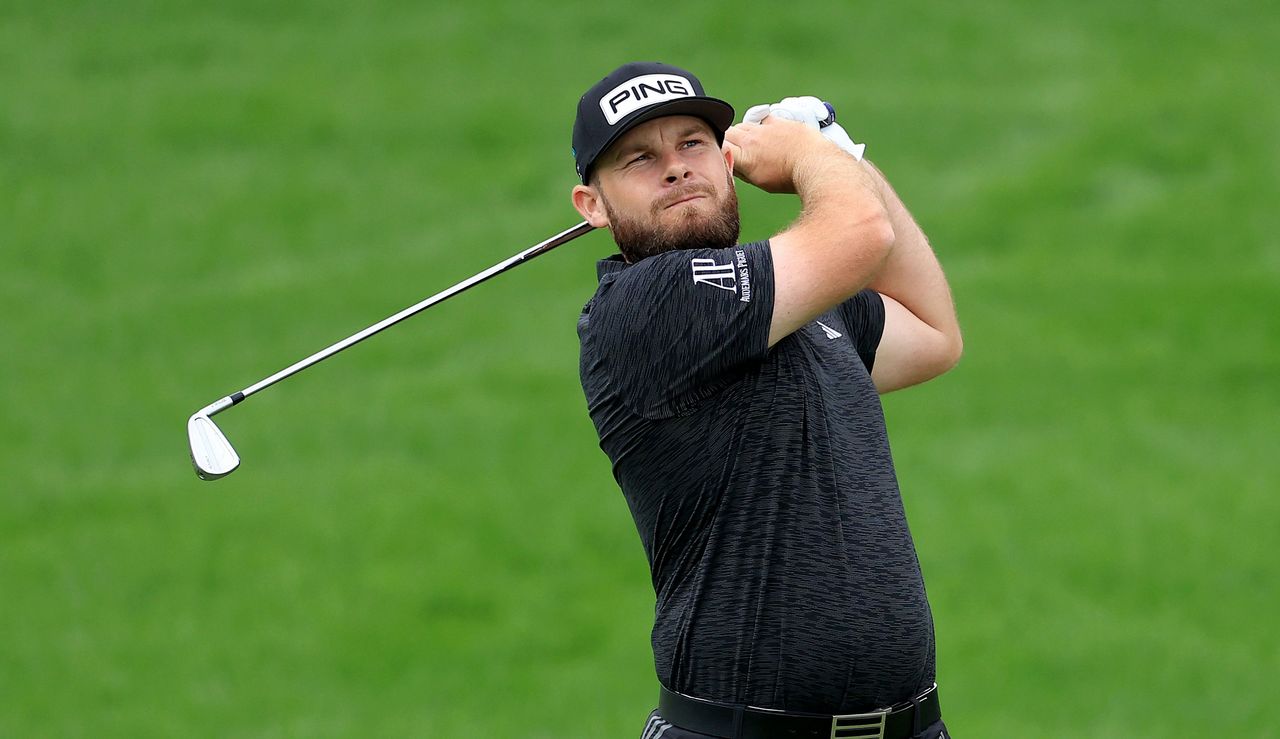 Hatton watches his iron shot while wearing a black polo shirt