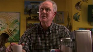 A scene with John Lithgow sitting on a barstool at a diner and holding a coffee cup in Dexter.