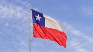 Chilean flag raised in good condition with blue sky in the background